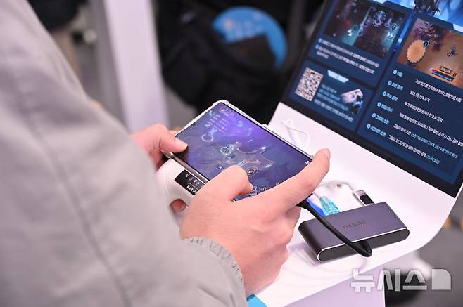 [부산=뉴시스] 윤정민 기자 = 14일 오전 부산 벡스코에서 진행 중인 '지스타 2025' 넷마블 부스에서 한 참관객이 '나 혼자만 레벨업: 카르마'를 시연하고 있다. 2025.11.15. alpaca@newsis.com