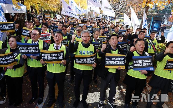 [서울=뉴시스] 이영환 기자 = 김택우 대한의사협회 회장 및 참석자들이 16일 오후 서울 여의도 국회 앞에서 열린 국민건강수호 및 의료악법저지를 위한 전국의사 대표자 궐기대회에서 구호를 외치고 있다. 2025.11.16. 20hwan@newsis.com
