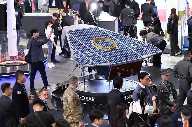 경기 고양시 킨텍스에서 열린 국제 항공우주 및 방위산업 전시회(ADEX)에서 한화 부스를 찾은 관람객들이 초저궤도 위성을 살펴보고 있다. 고양=뉴스1
