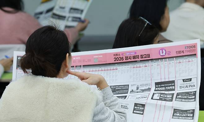 이투스에듀 주최로 15일 서울 강남하이퍼학원 본원에서 열린 ''2026 수능 가채점 설명회''에 참석한 수험생과 학부모들이 대학 배치 참고표를 살피고 있다. 연합뉴스
