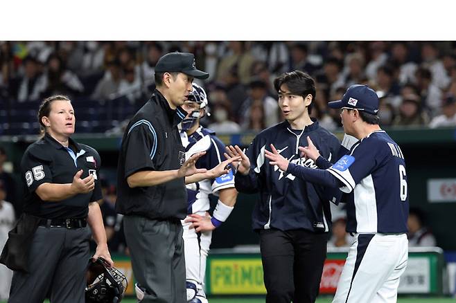 류지현 한국 야구대표팀 감독(오른쪽 첫번째)이 지난 15일 일본 도쿄돔에서 열린 일본과 평가전에서 5회 내야 안타가 돼야 할 문현빈의 타구를 플라이아웃으로 선언한 오심에 그라운드로 나가 항의하고 있다.  연합뉴스