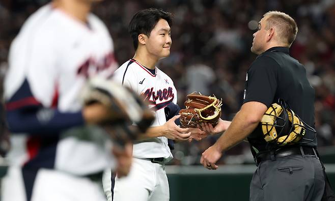 16일 일본 도쿄돔에서 열린 2025 K베이스볼 시리즈 대한민국과 일본의 평가전. 대표팀 선발투수 정우주가 3회 이닝을 마치고 더그아웃으로 향하던 중 심판에게 장비 점검을 받고 있다. 사진 | 도쿄=연합뉴스