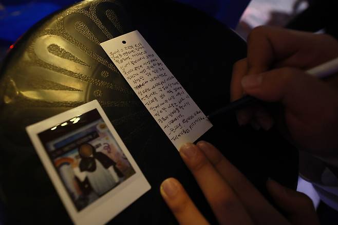 8일 저녁 서울 마포구 홍대입구역 6번 출구 인근에 설치된 ‘서울시립십대여성일시지원센터 나무’ 상담 천막에서 한 청소년이 포토월에서 찍은 사진을 두고 마지막 인사를 남기고 있다. 김혜윤 기자 unique@hani.co.kr