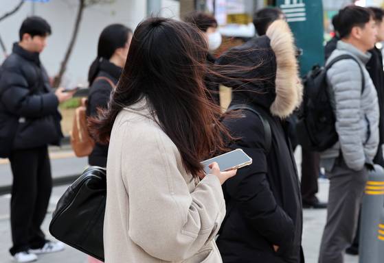 북쪽에서 찬 공기가 유입되면서 기온이 큰 폭으로 내려간 17일 오전 서울 종로구 광화문 네거리에서 한 시민의 머리카락이 바람에 날리고 있다. 뉴시스