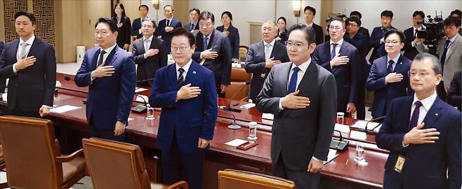 < “관세협상 타결, 기업인 큰 역할” > 이재명 대통령과 주요 대기업 총수 등이 16일 용산 대통령실에서 열린 ‘한·미 관세협상 후속 민관 합동회의’에서 국민의례를 하고 있다. 앞줄 왼쪽부터 정기선 HD현대그룹 회장, 최태원 SK그룹 회장, 이 대통령, 이재용 삼성전자 회장, 여승주 한화그룹 부회장. 뒷줄은 왼쪽부터 김용범 정책실장, 서정진 셀트리온 회장, 정의선 현대차그룹 회장, 구광모 LG그룹 회장, 김정관 산업통상부 장관. /김범준 기자