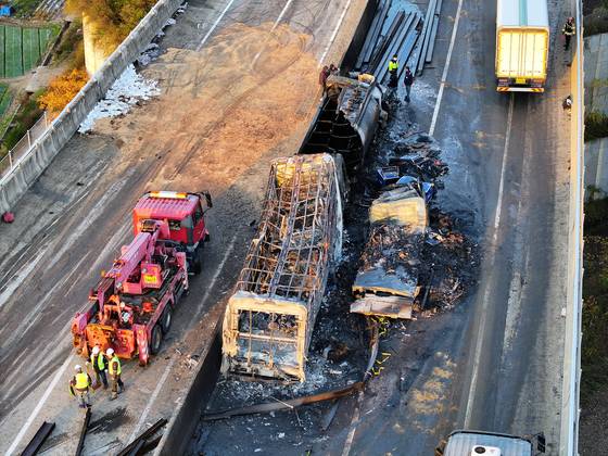 Officials work to clean up the scene after fire broke out due to a multi-vehicle collision involving a fuel tanker, several cargo trucks and passenger vehicles on the Sangju-Yeongcheon Expressway on Nov. 17. [YONHAP]
