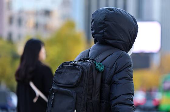 Pedestrians walk with thick clothes across the streets of Gwanghwamun in central Seoul on Nov. 10. [NEWS1]