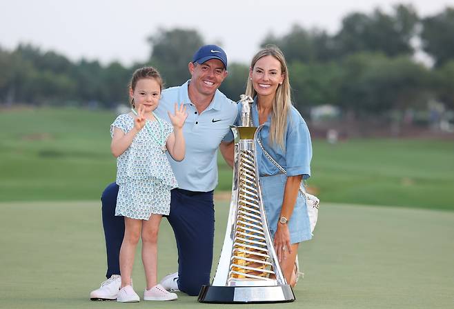 로리 매킬로이가 16일(현지시간) 아랍에미리트연합(UAE) 두바이의 주메이라 이스테이츠에서 끝난 DP월드 투어 챔피언십에서 시즌 챔피언 등극을 확정지은 뒤 트로피를 앞에 두고 가족과 함께 기념촬영을 하고 있다. 게티이미지코리아