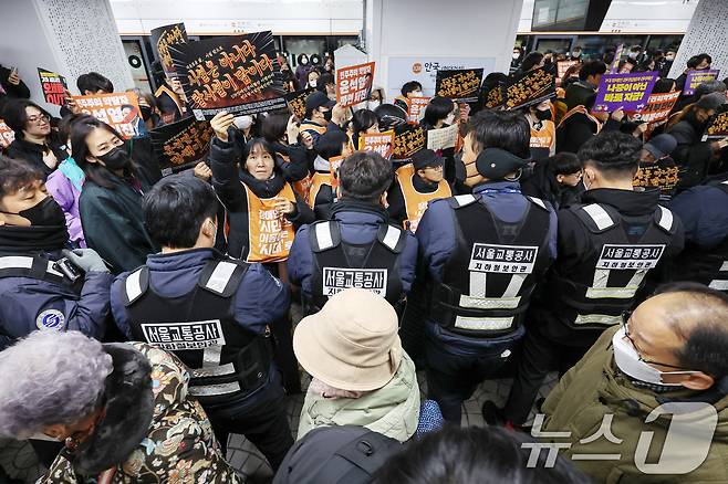 서울 종로구 3호선 안국역 승강장에서 새해 첫 출근길 지하철 탑승 시위에 나선 전국장애인차별철폐연대(전장연) 관계자들과 탑승 저지에 나선 서울교통공사 지하철 보안관들 뒤로 열차에서 하차한 시민들이 지나가고 있다. 2025.1.2/뉴스1 ⓒ News1 민경석 기자