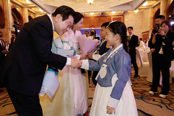 이재명 대통령과 김혜경 여사가 17일 아랍에미리트 아부다비에서 열린 동포만찬간담회에 참석해 화동에게 꽃다발을 받고 있다. 전민규 기자