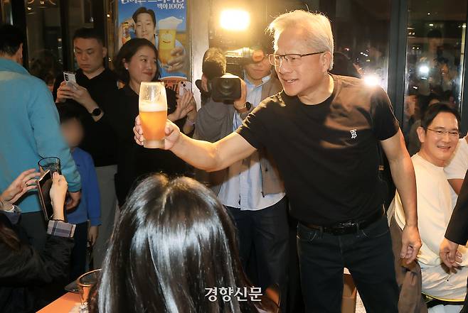 젠슨 황 엔비디아 최고경영자(CEO)가 지난달 30일 오후 서울 강남구 삼성역 인근 깐부치킨 매장에서 이재용 삼성그룹 회장, 정의선 현대차그룹 회장과 치킨 회동 중 내부 손님들과 잔을 부딪치고 있다.  권도현 기자