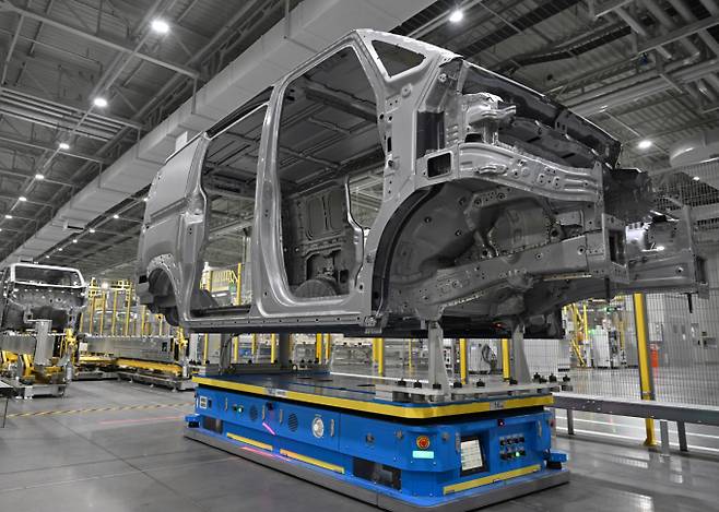 기아 화성 EVO 플랜트 내 무인운반차량(AGV)이 PV5 차체를 운반하는 모습. /사진=기아