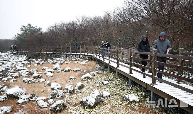 [제주=뉴시스] 우장호 기자 = 올 가을 들어 가장 추운 날씨를 보인 18일 오전 외국인 관광객들이 첫 눈이 쌓인 제주 한라산 1100고지 습지를 감상하고 있다. 2025.11.18. woo1223@newsis.com