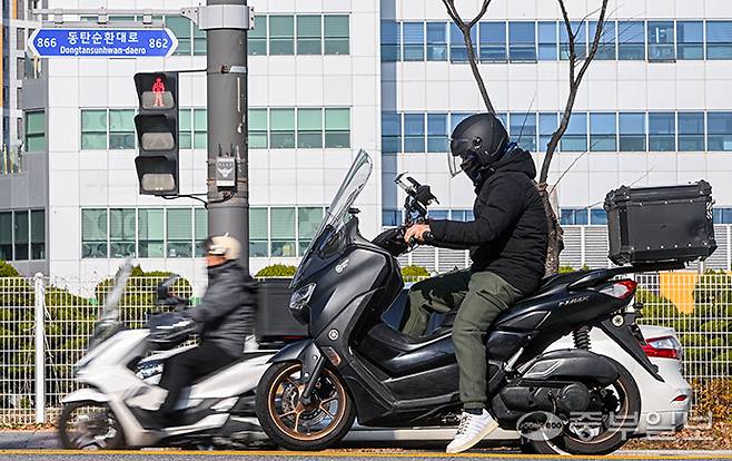 배달의민족이 올해 화성과 오산에 '로드러너'를 시범 도입한 것과 관련해 배달 라이더들과 소상공인들의 불만이 커지는 가운데 19일 오후 화성시 영천동 인근 횡단보도에서 배달 라이더가 신호를 기다리고 있다. 임채운기자