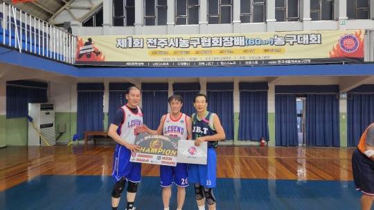 박정길 전주 농구동호인팀 전북연합 회장(오른쪽)이 우승팀에게 시상을 한 뒤 포즈를 취하고 있다.