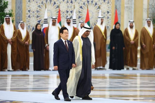 이재명 대통령이 18일(현지시간) 아랍에미리트(UAE) 아부다비 대통령궁에서 열린 국빈방문 공식 환영식에서 무함마드 빈 자이드 알 나흐얀 UAE 대통령과 함께 이동하고 있다. 연합뉴스
