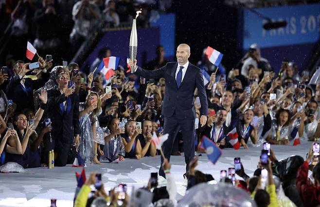 지네딘 지단 전 레알 마드리드 감독이 지난해 7월 파리올림픽 개막식에서 성화를 들고 입장하고 있다. Getty Images코리아