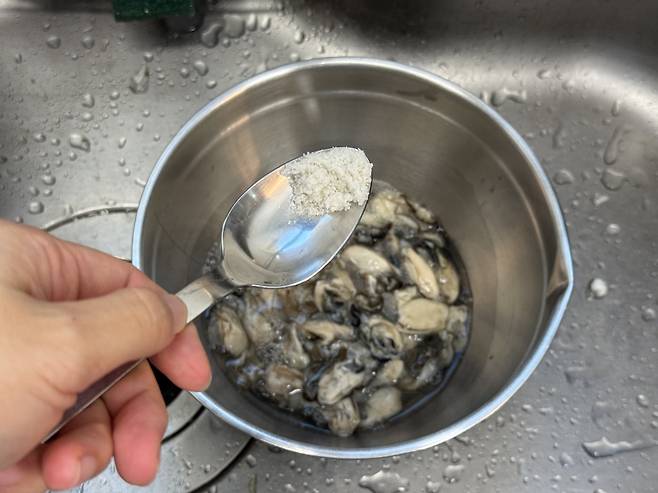 굴 비린내를 잡기 위해 소금으로 세척하는 모습