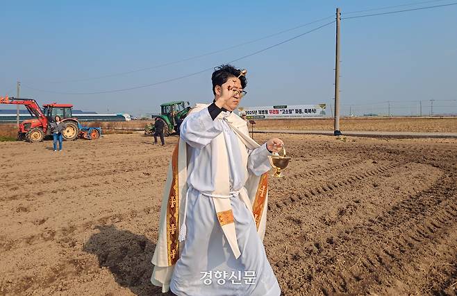 유정현 신부가 13일 밀밭축복식에서 성수를 뿌리고 있다.
