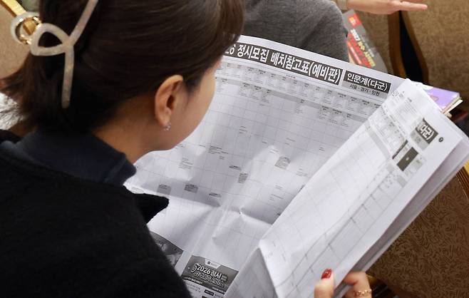 2026학년도 대학수학능력시험 다음날인 14일 서울 광진구 세종대학교에서 열린 2026 정시 합격예측 및 전략 설명회에서 학부모들이 배치참고표를 보고 있다. [연합]