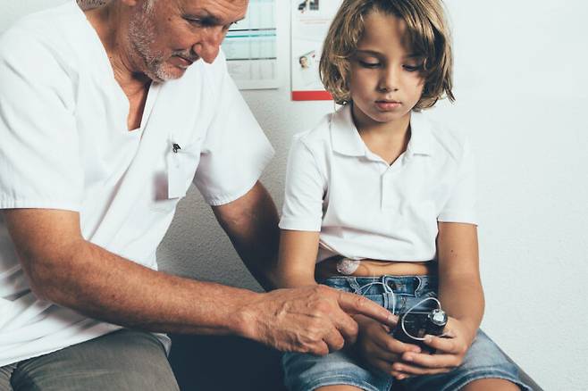 인슐린 펌프를 사용에 대한 설명을 듣고 있는 아이의 모습. 사진=게티이미지뱅크