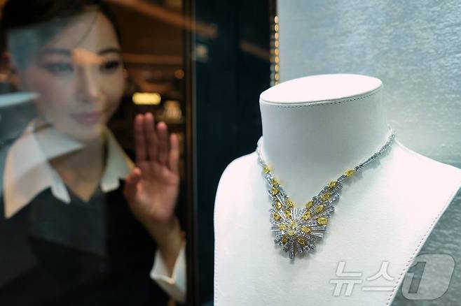 모델이 약 38캐럿의 다이아몬드가 장식된 목걸이를 바라보는 모습. (롯데백화점 제공) 2024.12.1/뉴스1