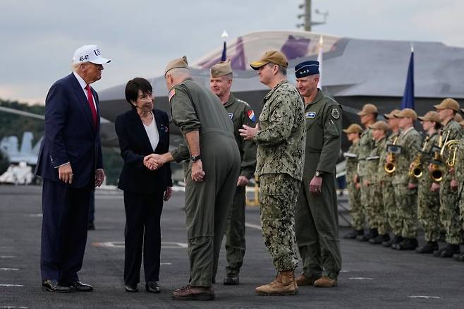 지난달 28일 일본 가나가와현 요코스카의 미군 기지에서 도널드 트럼프 미국 대통령(왼쪽 첫번째)과 함께 미국 해군 항공모함에 탑승한 다카이치 사나에 일본 총리(왼쪽 두번째)가 미군 관계자와 악수하고 있다.AP연합뉴스
