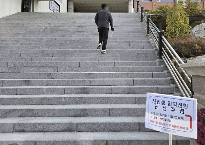 한 학부모가 지난 20일 서울 중곡동 대원국제중에서 진행된 2026학년도 신입생 추첨 참관에 참석하기 위해 자녀의 접수증을 들고 강당으로 향하고 있다. 이미경 기자