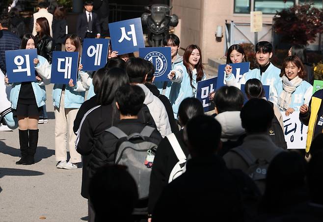 Applicants enter the Hankuk University of Foreign Studies campus in Dongdaemun-gu, Seoul, on Nov. 16, to cheers from the university students. (Yonhap)
