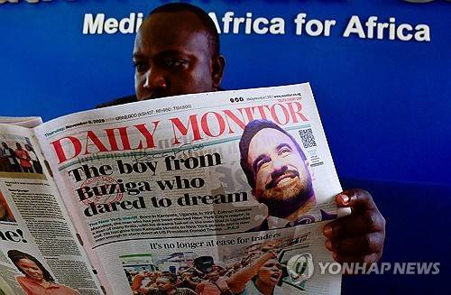 우간다 출신 맘다니 당선 소식이 실린 신문을 보는 우간다 남성  [로이터 연합뉴스 자료사진. 재판매 및 DB 금지]