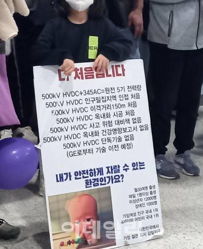 한 어린이가 동서울 변전소 증설 관련해 ‘내가 안전하게 자랄 수 있는 환경인가요?’라고 쓰인 팻말을 들고 있다. (사진=최훈길 기자)