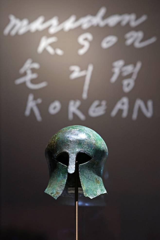 국립중앙박물관은 올해 광복 80년을 맞아 손기정 특별전 '두 발로 세계를 제패하다'를 연말까지 열고 있다. 1936년 베를린 올림픽 금메달과 월계관, 특별 부상품이었던 고대 그리스 투구 등 전시품 18건을 선보인다. 배경은 손기정이 당시 유럽에서 팬들에게 해준 사인. /뉴시스