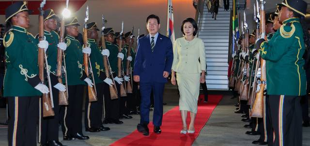 주요 20개국(G20) 정상회의에 참석하는 이재명 대통령이 김혜경 여사와 함께 21일(현지시간) 남아프리카공화국 요하네스버그 OR탐보국제공항에 도착한 뒤 공군 1호기에서 내려 이동하고 있다. 연합뉴스