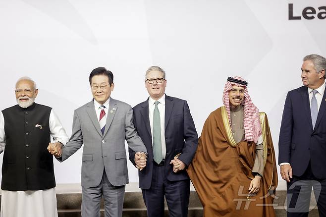 22일(현지시간) 남아공 요하네스버그에서 열린 주요 20개국(G20)에서 정상들이 단체 사진을 촬영했다. 사진은 이재명 대통령이 나렌드라 모디 인도 총리(왼쪽 첫번째), 키어 스티머 영국 총리(가운데)와 손을 잡고 있는 모습. 우측엔 파이살 빈 파르한 알 사우드 왕자 사우디아라비아 외교부 장관, 파블로 키르노 아르헨티나 외교부 장관이다. ⓒ 로이터=뉴스1 ⓒ News1 최종일 선임기자
