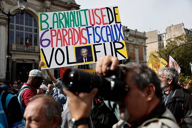 지난달 2일 프랑스 파리에서 '베르나르 아르노 LVMH 모에 헤네시 루이비통 회장 겸 CEO가 6개 조세 피난처를 이용한다'는 슬로건이 적힌 플래카드를 든 시위대. /연합뉴스