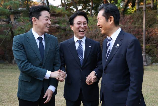 김민석(가운데) 국무총리가 서울 종로구 총리공관에서 열린 고위당정협의회에서 강훈식(왼쪽) 대통령 비서실장, 정청래 더불어민주당 대표와 손을 잡고 있다. [연합뉴스]