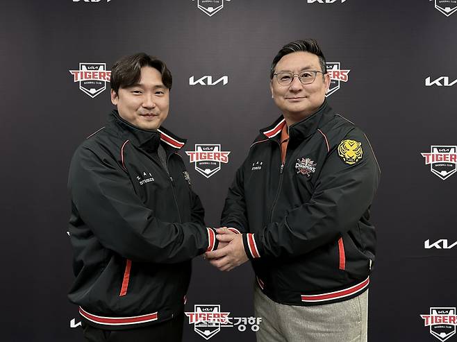 좌완 이준영(왼쪽)이 지난 22일 KIA와 FA 계약을 맺고 잔류한 뒤 심재학 KIA 단장과 악수하고 있다. KIA 타이거즈 제공