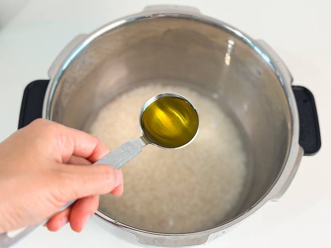 찰기가 좋고 잡내 없는 밥을 위해 밥 지을때 비법 재료를 더하는 모습