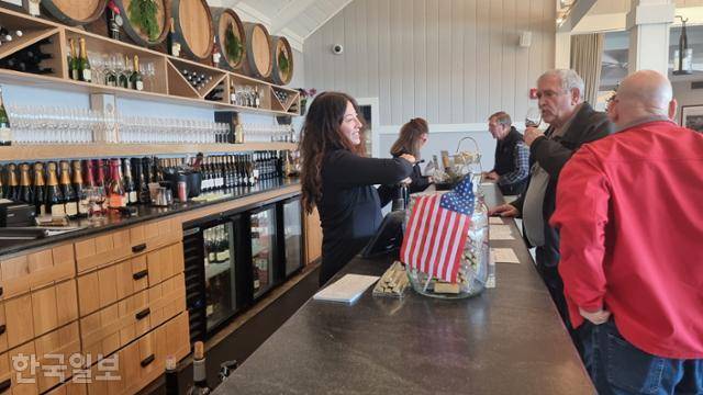 12일 미국 버지니아주 샬러츠빌 ‘트럼프 와이너리’ 와인 시음장의 고객과 바텐더 사이에도 성조기가 놓여 있다. 샬러츠빌=권경성 특파원