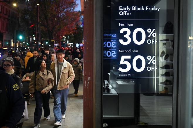 23일(현지시간) 영국 런던 옥스퍼드 스트리트의 모습. 벽면에는 다가오는 블랙프라이데이를 맞이해 할인 행사를 진행하고 있다는 내용의 광고가 걸려있다. [로이터]