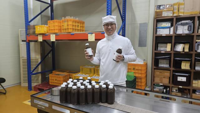 함양군 유림면에 위치한 농업회사법인 ‘그농부’ 가공 공장에서 김성균 대표가 생산된 생강차 완제품을 들어 보이며 환하게 웃고 있다./박준영 기자/