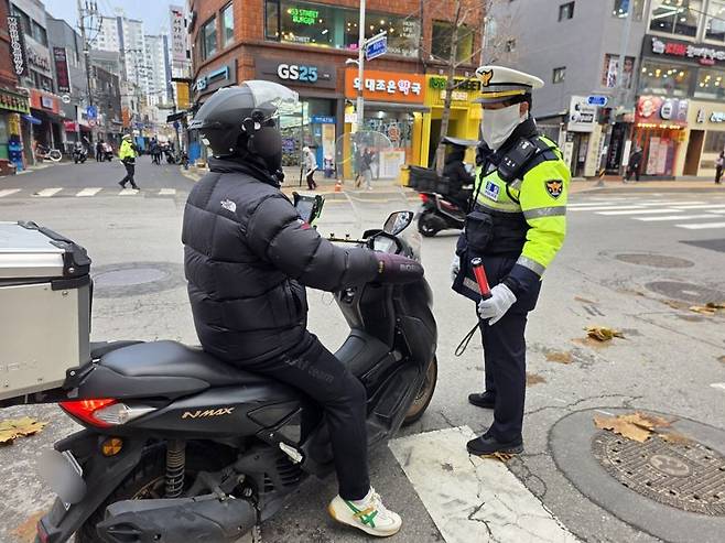 25일 오후 서울 동대문구 한국외국어대학교 인근에서 오토바이 배달기사 장모씨가 인도 주행으로 단속되고 있다. 사진=박성현 기자
