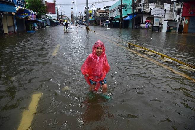 23일(현지시간) 태국 남부 나라티왓주에서 한 어린이가 폭우로 불어난 물을 헤치며 이동하고 있다. AFP연합뉴스