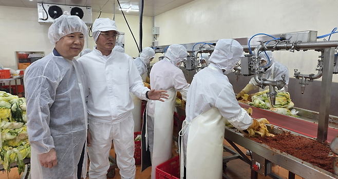 옥천호 삼성전자 스마트공장지원센터 위원과 민병철 평창꽃순이 대표(왼쪽부터)가 삼성전자 스마트공장 지원 사업으로 김치 속넣기 작업 효율을 향상시킨 ‘김치 속 자동 충진기’ 적용 현장을 점검하고 있다. 삼성전자