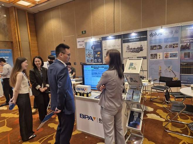 TOC Asia의 부산항만공사 기술전시 부스에서 네트워킹 중인 참관객들.