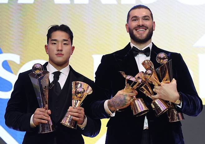 2025 프로야구 최우수선수(MVP) 폰세(오른쪽)와 신인왕 안현민이 24일 서울 송파구 롯데호텔 월드에서 열린 시상식에서 트로피를 들고 나란히 포즈를 취했다. 폰세는 MVP 트로피에 투수 4관왕 트로피까지 5개, 안현민은 신인왕 트로피와 출루율 1위 트로피를 들고 있다. 뉴스1