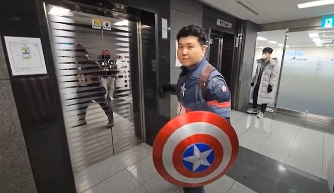 ‘윤석열 방어권 안건’이 인권위 전원위에 상정된 2025년 2월10일, 캡틴 아메리카 복장을 한 안병희씨가 인권위 14층 엘리베이터 앞에 서 있다. MBC 뉴스데스크 화면 갈무리