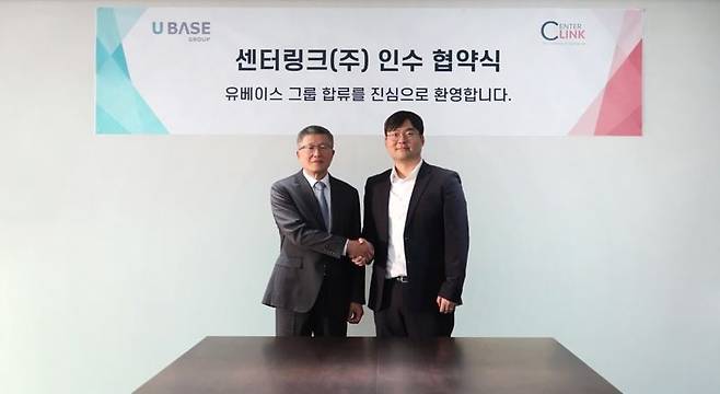 김성태 센터링크 대표(왼쪽)와 권기둥 유베이스 그룹 경영혁신총괄이  지난 20일 서울 중구 유베이스 그룹 본사에서열린 인수 협약식을 마친 뒤 악수하고 있다. 유베이스 그룹 제공
