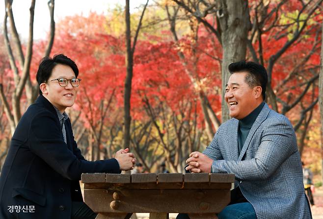 박태현 SM C&C 대표(오른쪽)와 이성수 SM엔터테인먼트 CAO가 지난 20일 서울 성동구 성수동 서울숲 벤치에 마주 앉아 담소를 나누다 함박웃음을 짓고 있다.  정지윤 선임기자