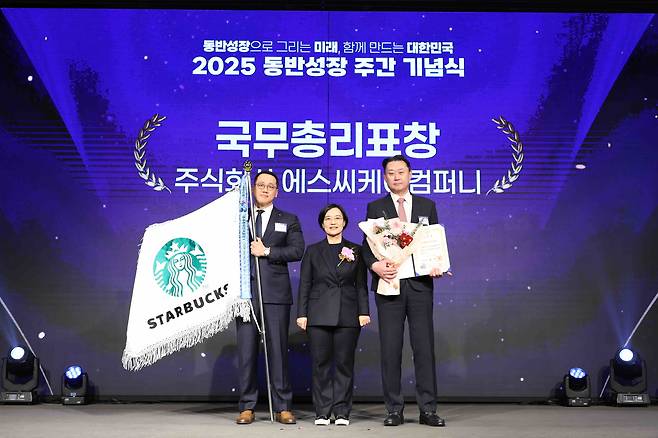 Starbucks Korea CEO Sohn Jeong-hyun, far right, receives the Prime Minister’s Citation at the 2025 Win-Win Growth Index ceremony held at the Korea Federation of SMEs in western Seoul on Nov. 25. Minister of SMEs and Startups Han Seong-sook stands at the center, and to the far left is a Starbucks employee. [STARBUCKS]
